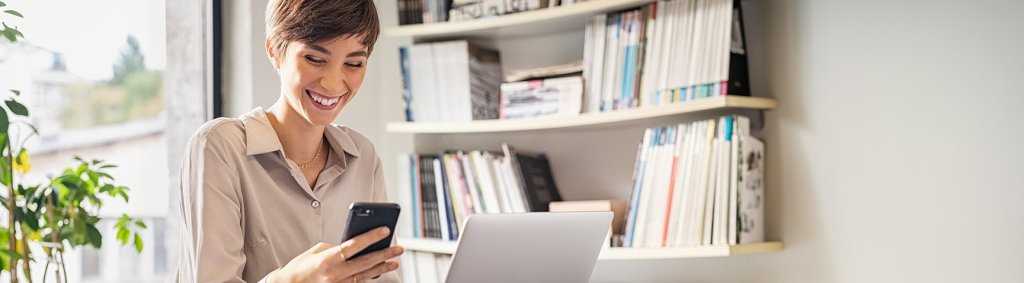 Eine junge Frau am Smartphone im Wohnzimmer. | Une jeune femme avec un smartphone dans le salon. | A young woman with a smartphone in the living room.